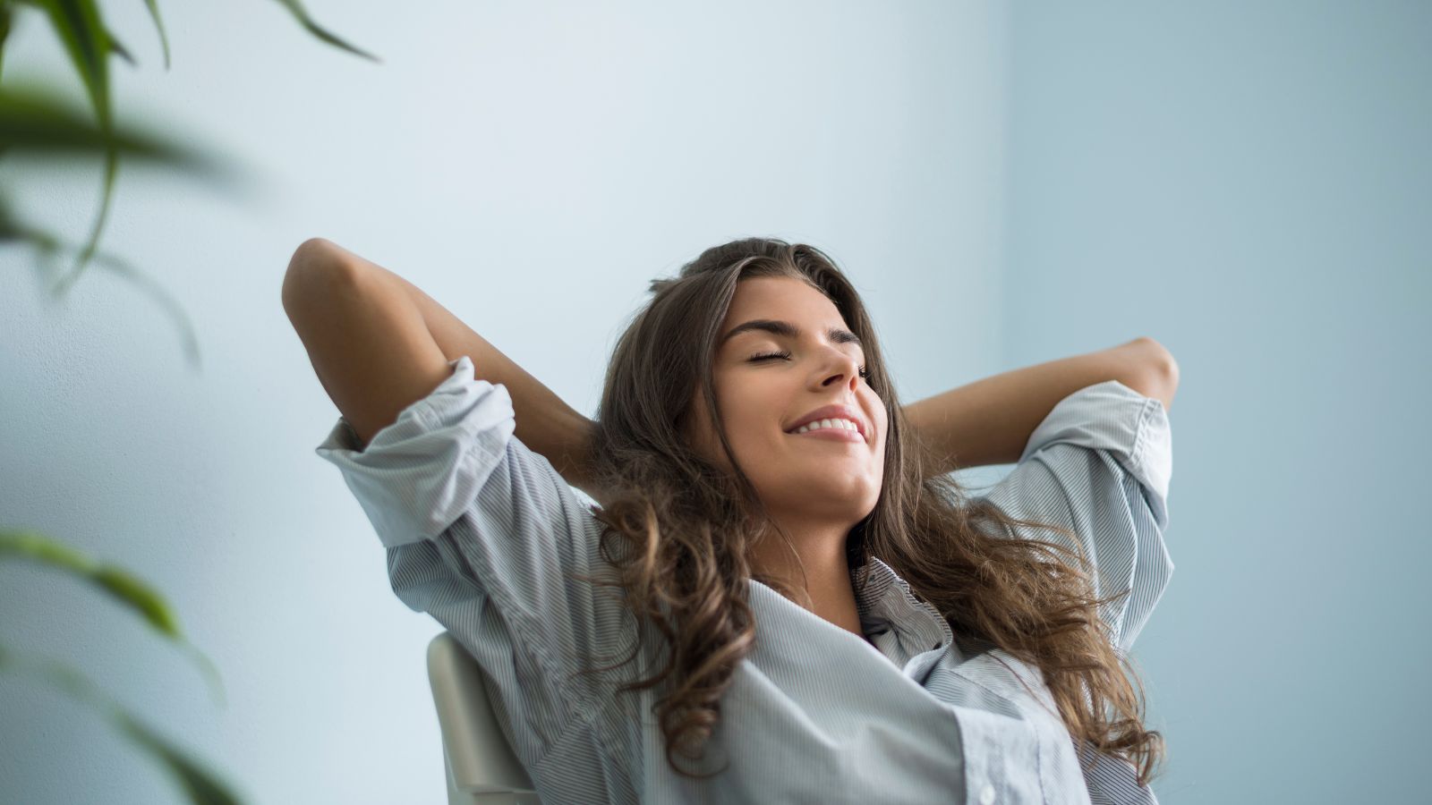 Mulher sentada em cadeira com braços para cima