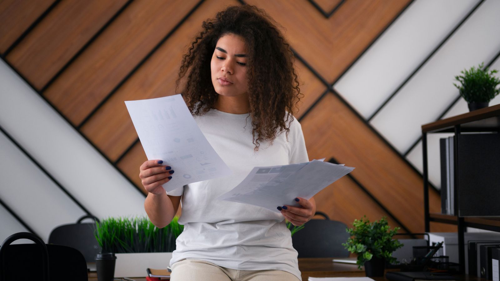 mulher negra em pé analisando papéis.