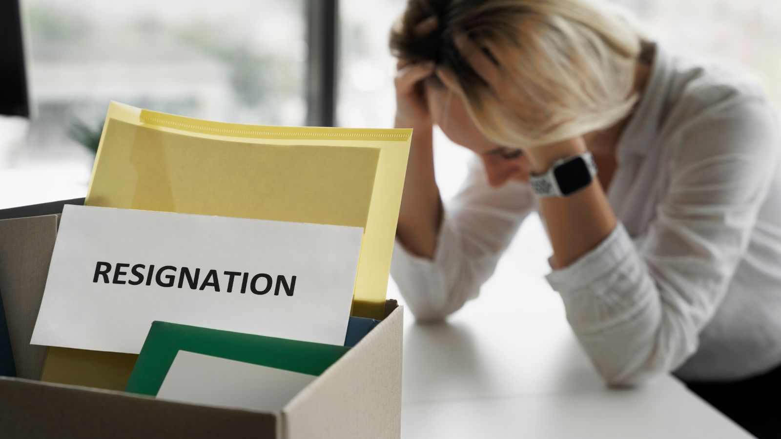 Pessoa frustrada, com seus pertences após demissão