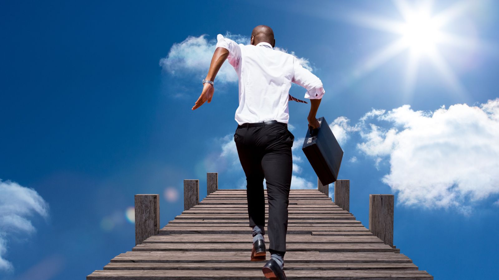 Homem subindo escada em direção ao céu