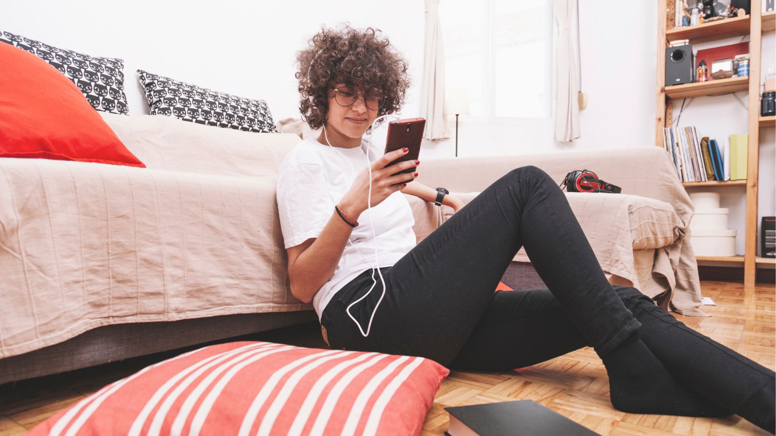 Mulher lendo pelo celular sentada no chão