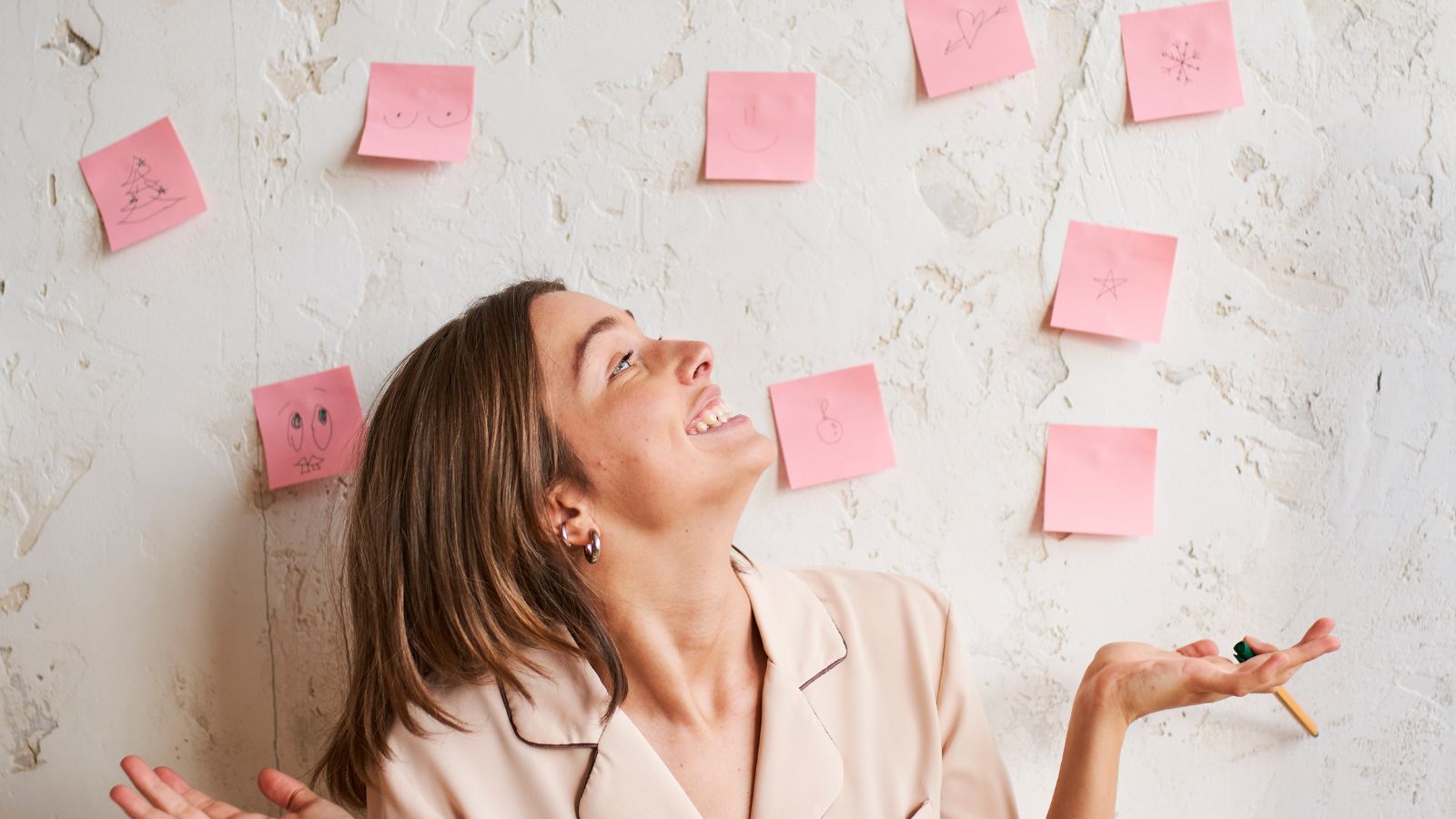 Mulher sorrindo para metas em post it
