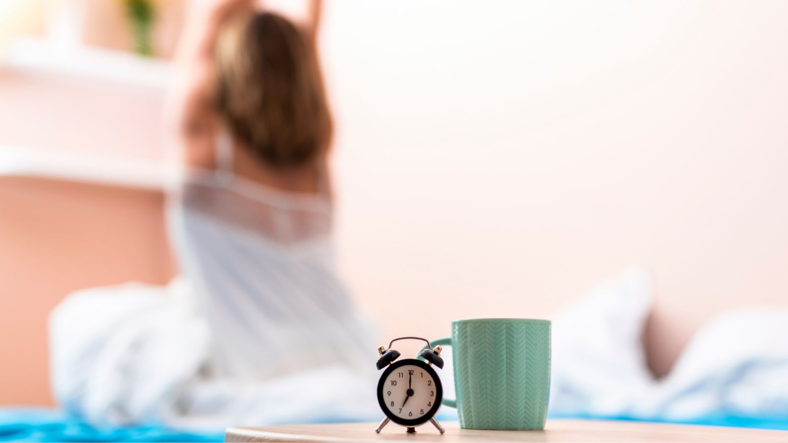 Mulher despertando com relógio e xícara em foco na frente