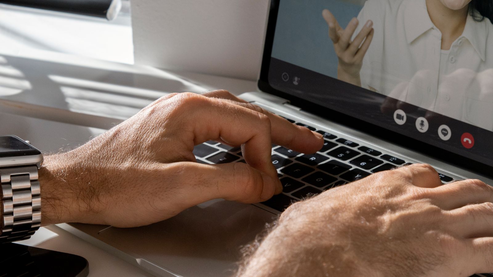 Pessoa mexendo em computador em chamada de vídeo