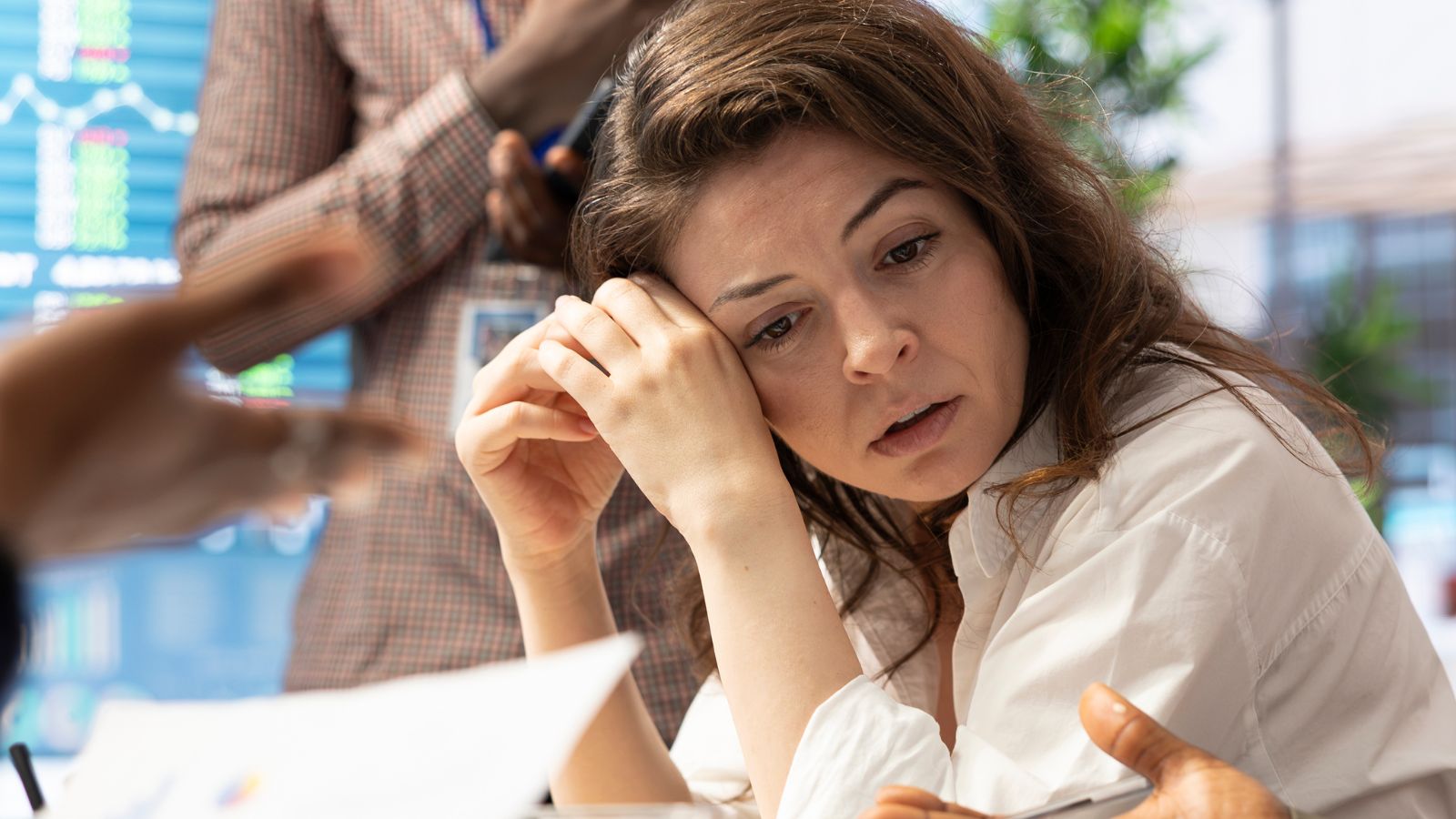 Mulher com semblante triste acompanhando reunião