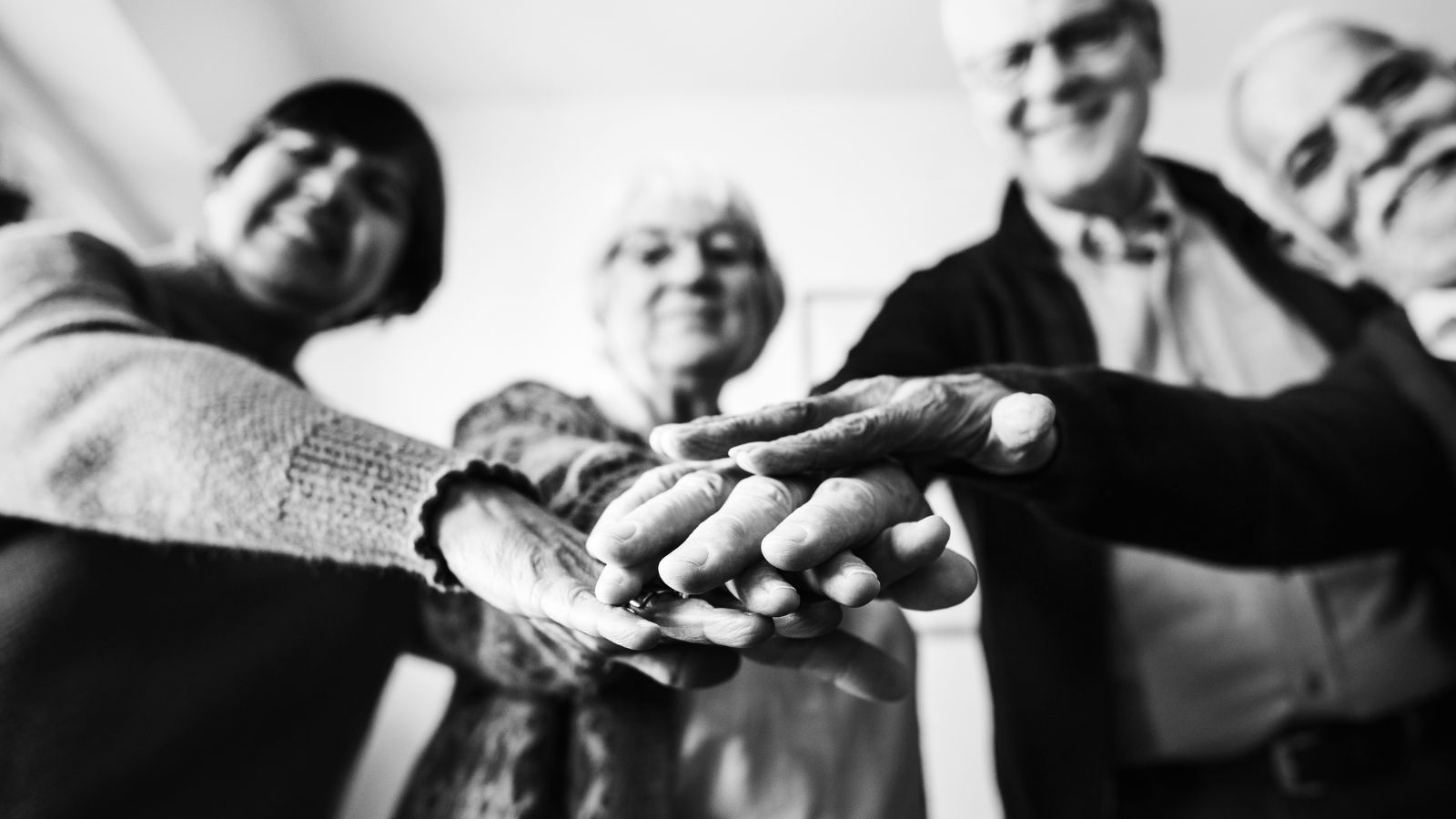 Idosos juntando as mãos em preto branco